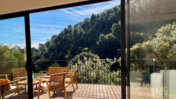 A balcony with a wooden deck, wicker chairs, and a table. - Vacation home, 250 m from the beach (Théoule-sur-Mer)