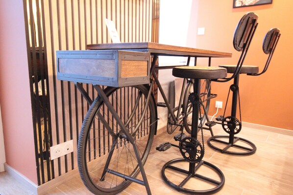A bicycle converted into a table and chair, with a wooden frame and metal parts.
