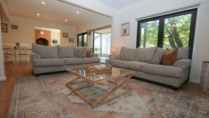 A living room with two grey sofas, a glass coffee table, and a patterned rug.