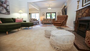 A living room with a green sofa, a brown armchair, and a fireplace.