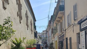 A narrow street with buildings on either side, potted plants lining the sidewalk, and a clear sky above. - Cosy apartment, right in the center, 200m from the port  (La Ciotat)