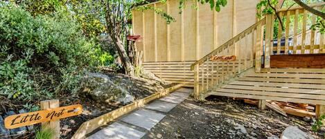 A wooden deck with a staircase leading to a wooden structure labeled 'Little Nest.'