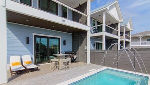 A modern two-story building with a swimming pool, outdoor seating, and a barbecue area. - SunKissed @ St. George Island (Eastpoint)