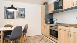 Una cocina moderna con armarios de madera, estufa a gas y cafetera.
