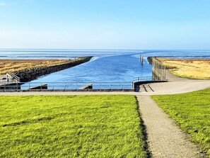 A coastal pathway leading to a body of water, with a grassy area and a small structure on the left. - 2 Person Holiday Home in Hojer (Højer)
