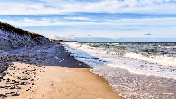 Una playa con arena y olas.