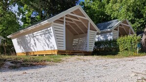 Un petit bâtiment d’un seul étage, doté d’un toit en pente et d’une terrasse en bois.