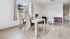 Un comedor moderno con una mesa de madera, dos sillas y una mesita auxiliar.