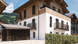 A modern multi-story building with a wooden facade and balconies. - Apartment in Kirchberg Near Ski Lift (Kirchberg in Tirol)