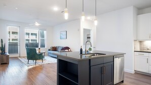 A modern kitchen with a central island, built-in appliances, and pendant lighting. - Westerly (Dallas)