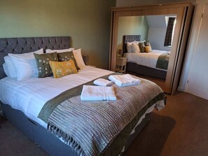 Relax in comfort with a large bed, tufted headboard, and plush linens.
