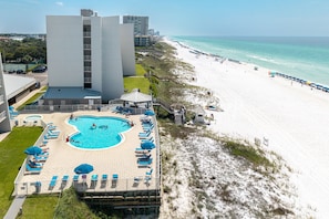 A hotel with a swimming pool, beach access, and a view of the ocean.