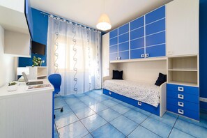 A room with a desk, chair, bed, and storage units. - Appartamento Sally in Sorrento (Sorrento)