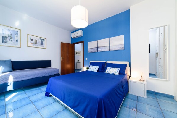 A bedroom with a large bed, a sofa, and a nightstand. - Appartamento Sally in Sorrento (Sorrento)