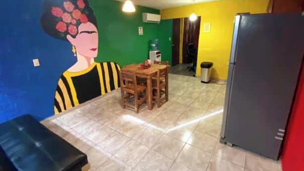 Un comedor con mesa y sillas, un refrigerador y un dispensador de agua.