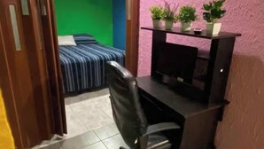 Una habitación con escritorio, silla y plantas en macetas.