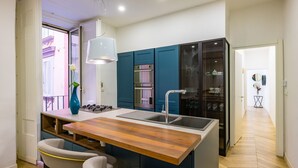 Een moderne keuken met een centraal eiland, een inbouwoven en een koelkast.