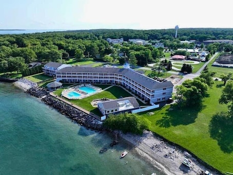 A large, curved hotel with a pool and a view of the water.