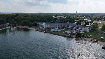 Een hotel aan het water met een zwembad, een steiger en uitzicht op het omliggende bos.