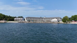 Un hotel sul lungomare con numerosi balconi, una zona esterna coperta e vista sull'acqua.