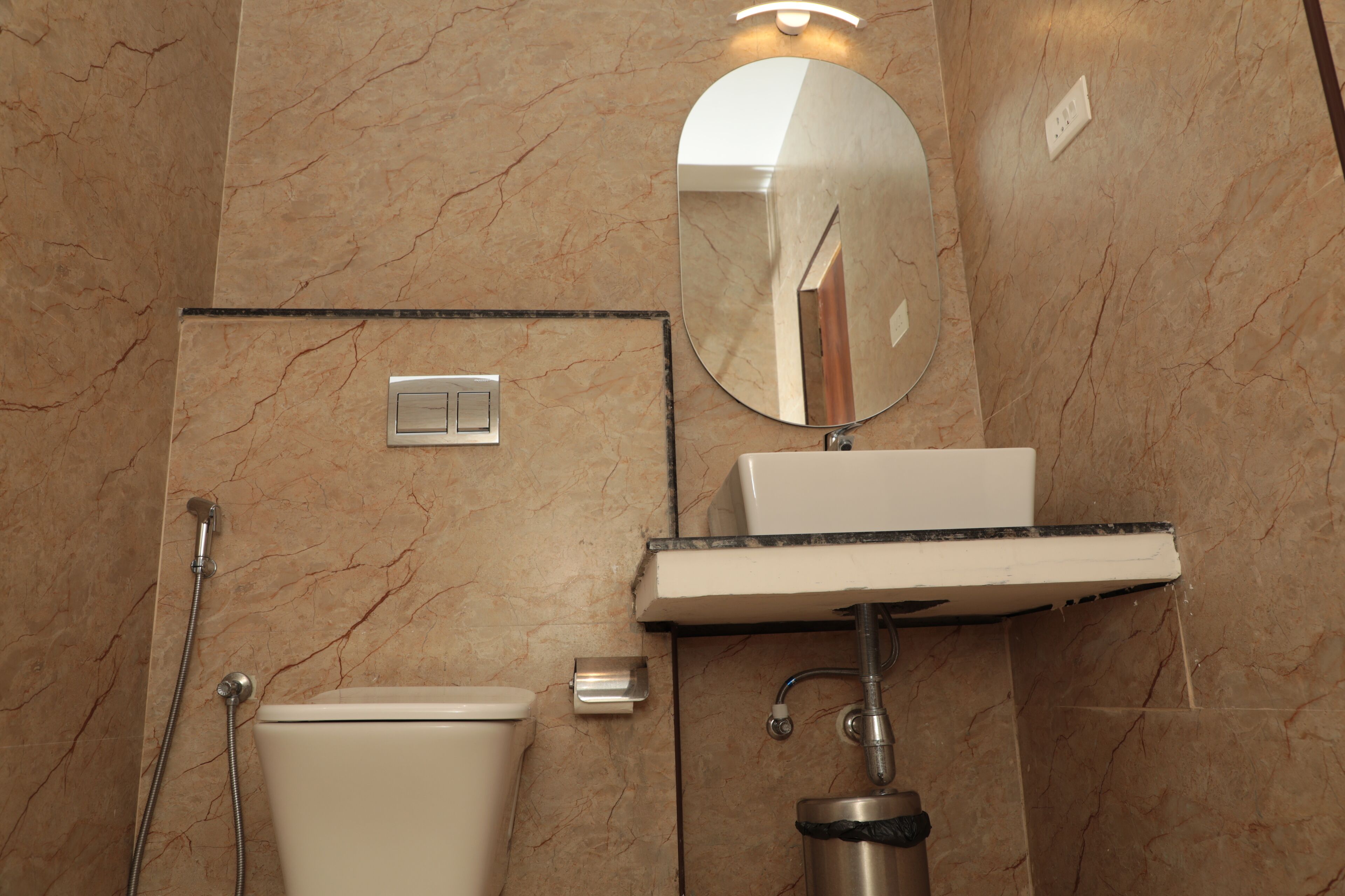 A bathroom with a toilet, sink, mirror, and shower.