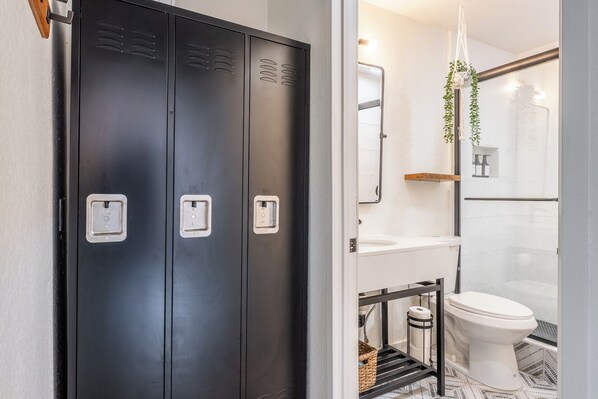 Ein modernes Badezimmer mit einem schwarzen Kleiderschrank, einer weißen Toilette und einer Duschkabine.