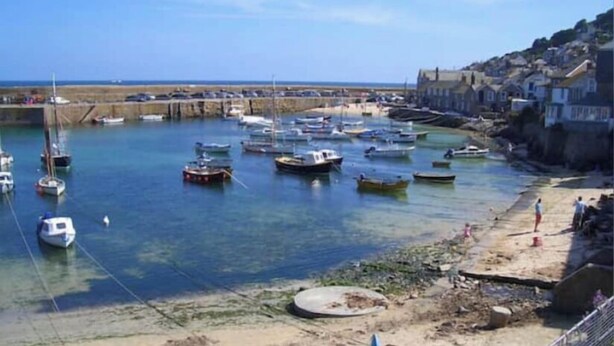 A harbor with boats docked, a sandy beach, and buildings along the shore. - Cottage - Sleeps 4 - Fireplace - Internet (Penzance)