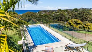 A rectangular swimming pool with a clear view of the ocean and surrounding greenery. - Ciao Korora - The Classic (Korora)