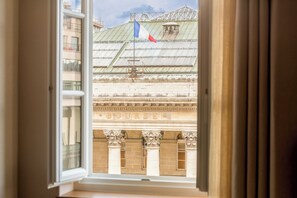 A view through an open window of a building with a sign that reads "BOURSE."