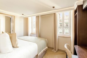 A hotel room with a bed, a chair, a desk, and large windows. - Merveil - Signature Suite - Louvre - Bourse II (Paris)