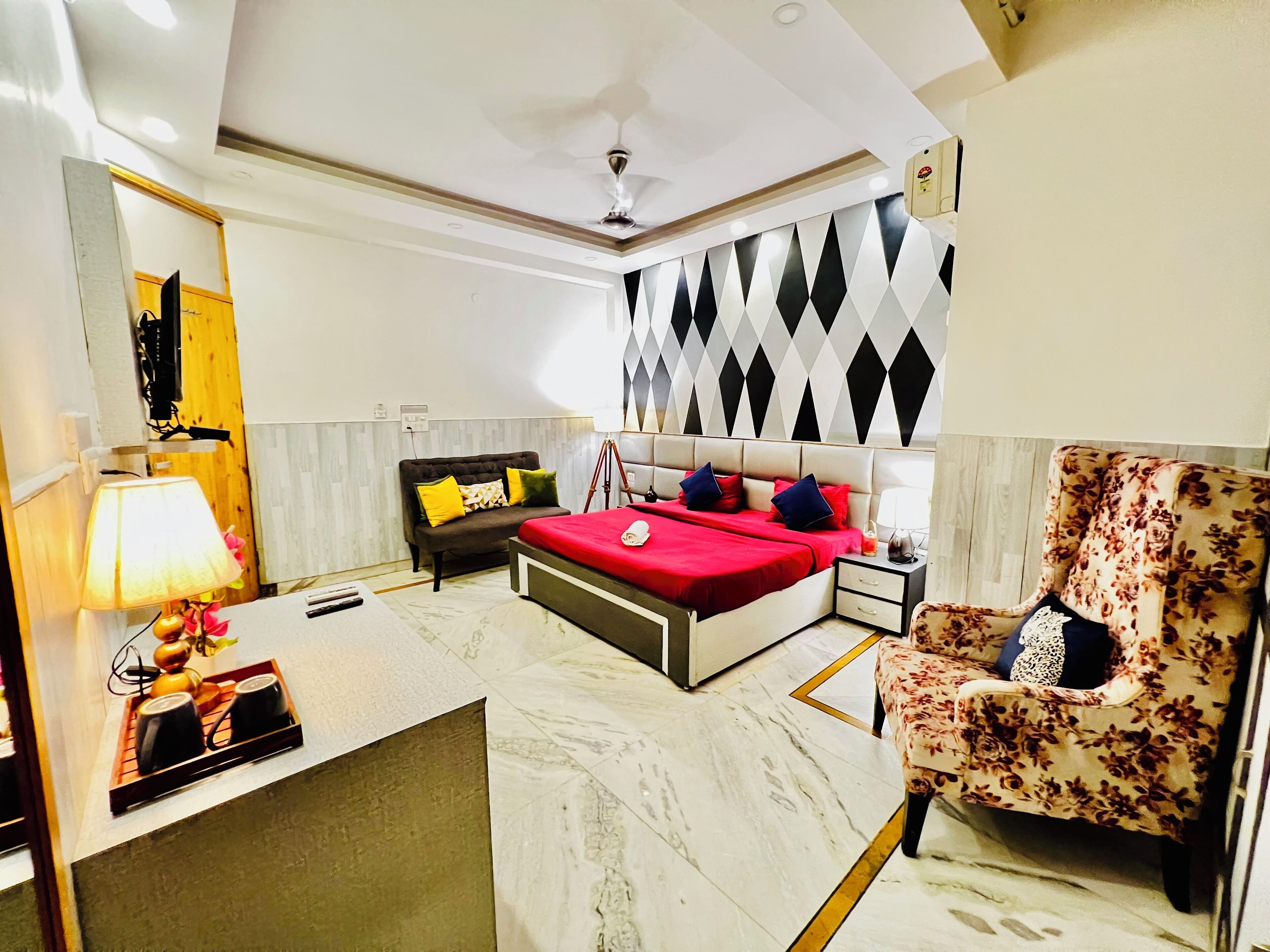 A modern bedroom with a bed, a chair, a desk, and a lamp.