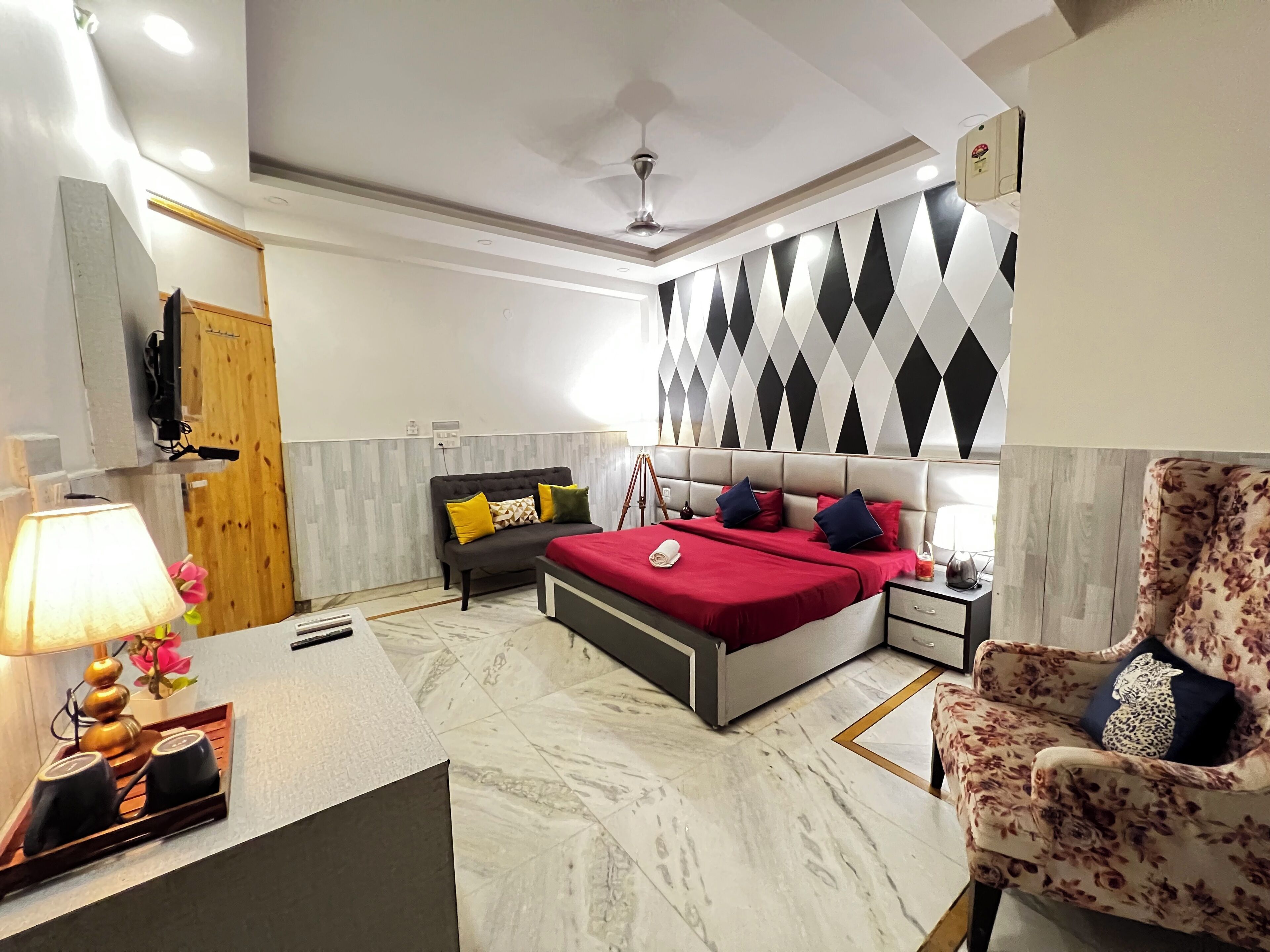 A bedroom with a bed, bedside tables, a chair, a lamp, and a decorative wall.
