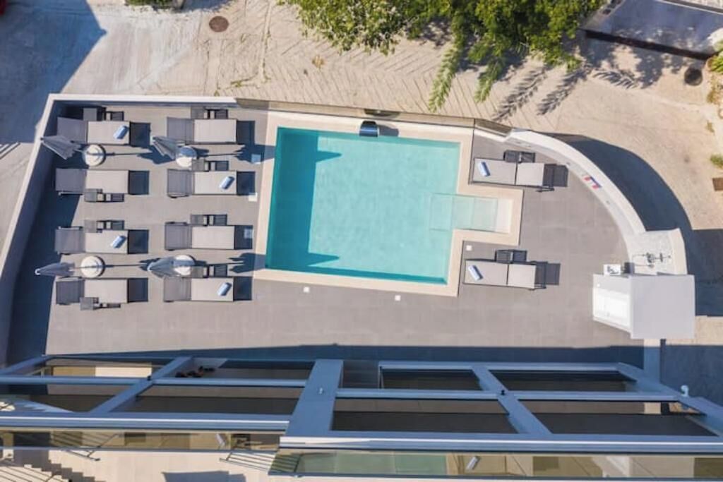 A rooftop pool area with sun loungers and a small pool.
