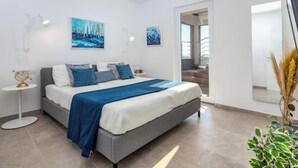 A modern bedroom with a bed, a side table, and artwork on the walls. - Villa Poco Loco - Deluxe Apartment with Sea View (Dubrovacko-neretvanska županija)