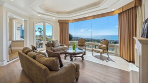 A spacious living room with a large window offering a view of the ocean, furnished with a sofa, armchairs, and a coffee table. - Private Pool/Spa/Open October/Sauna/Amazing La Jolla Views (La Jolla)