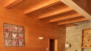 A cozy room with a large bed, a small table, a chair, and a wall-mounted shelf. - Large apartment in village center with direct access to ski and hiking trails (Prémanon)