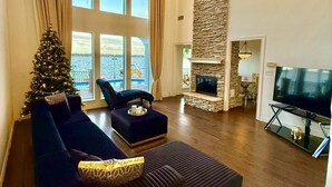 Un salón amplio con un ventanal grande, chimenea y televisor.