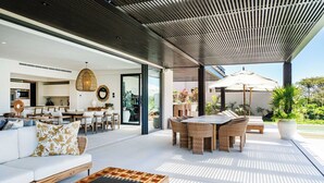 Un espace de vie moderne à aire ouverte comprenant un coin repas, un canapé et une table basse.