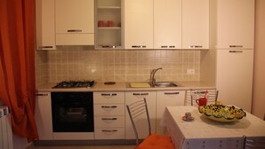 A compact kitchen with white cabinets, a gas stove, a dishwasher, and a sink. - Cozy mini-apartment ideal for a couple. (Tropea)