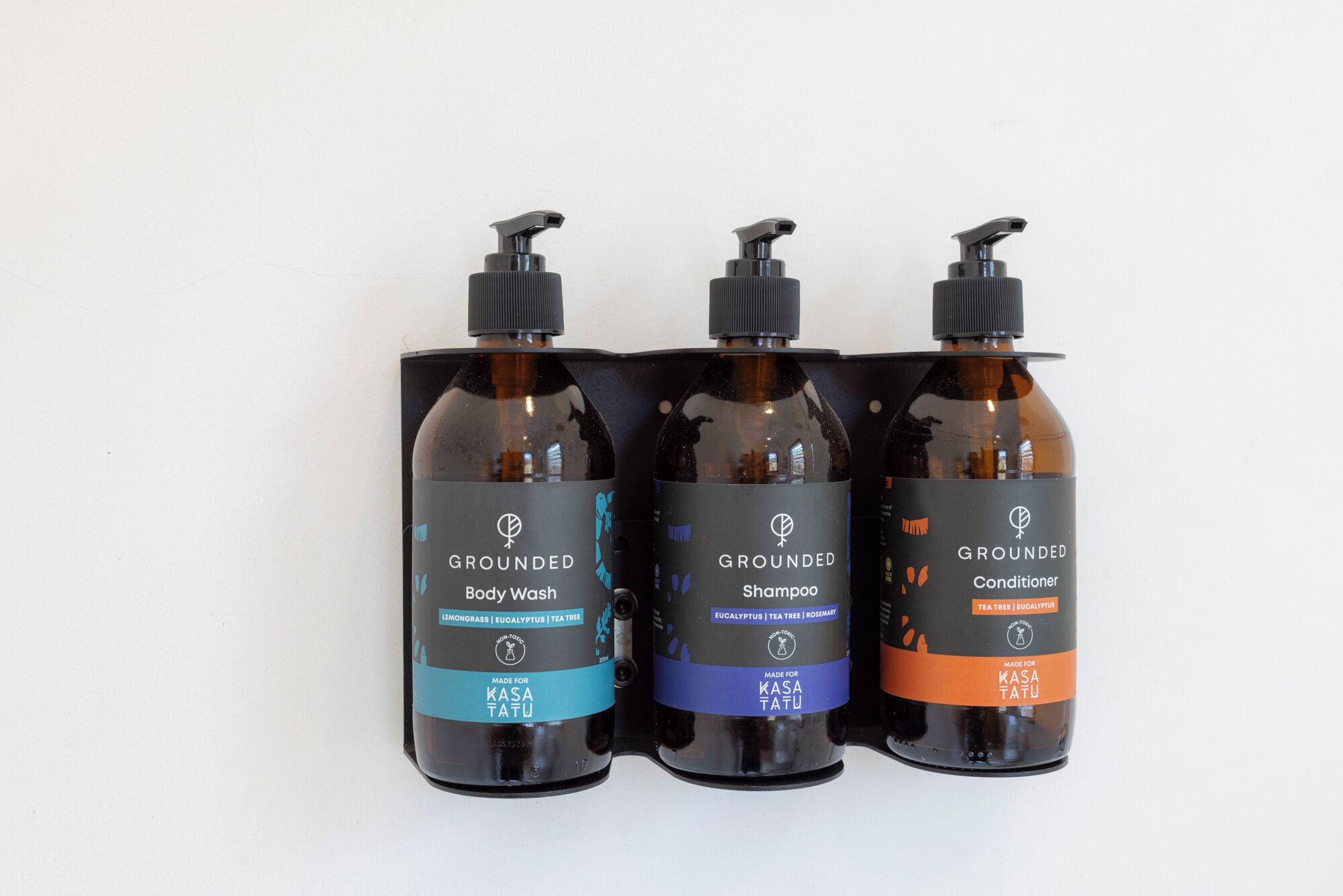 Tre flaconi di bagnoschiuma, shampoo e balsamo Grounded.