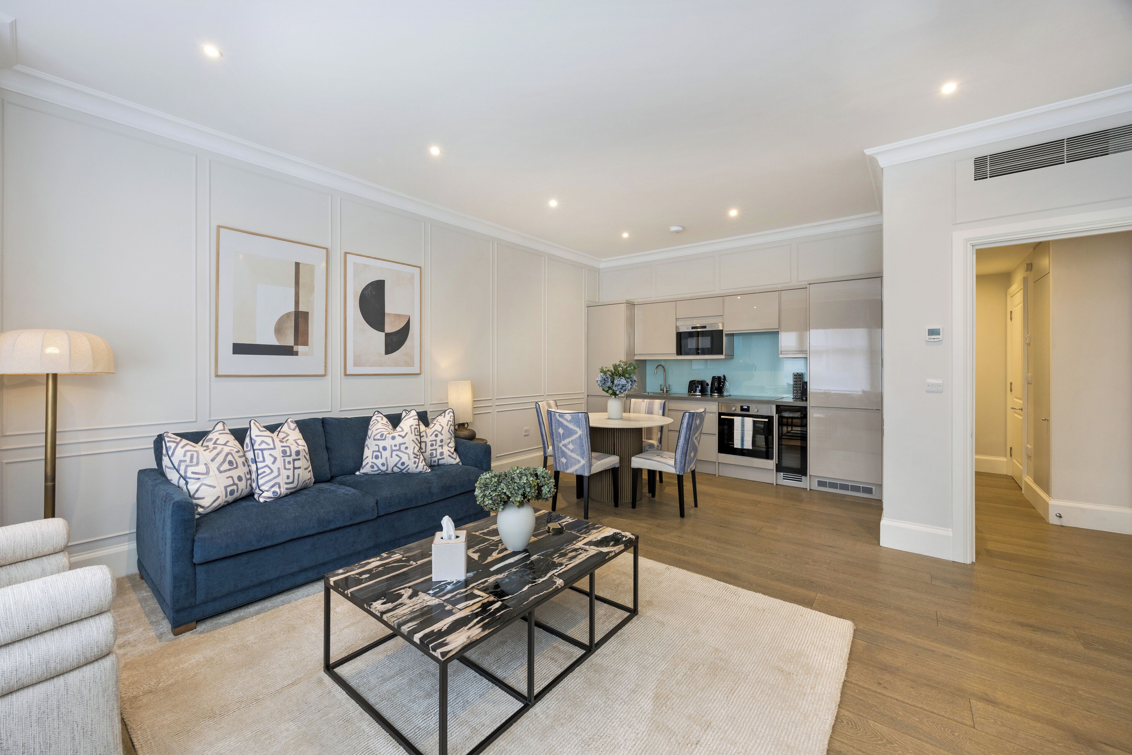 A modern living room with a sofa, coffee table, and dining area.