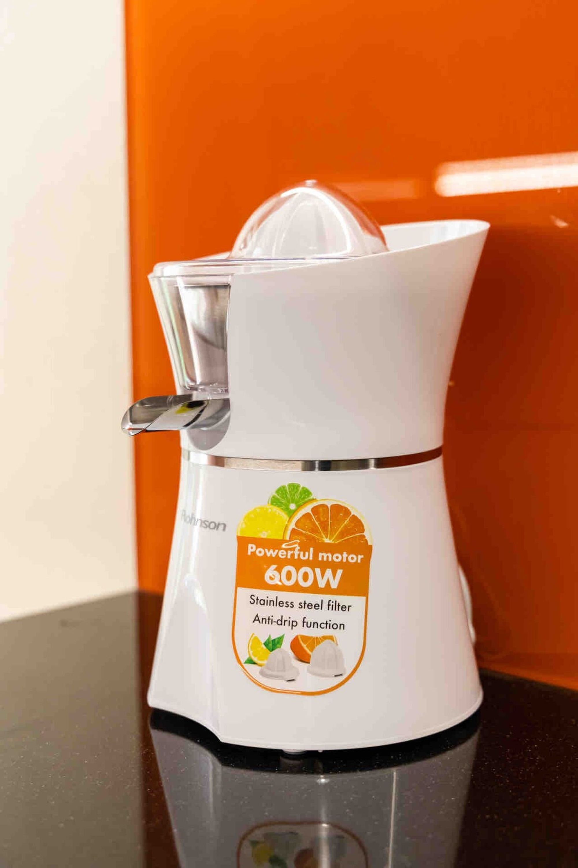 En vit köksapparat med ett filter i rostfritt stål och en funktion som förhindrar dropp, och som har etiketten ”Kraftfull motor 600 W”.