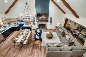 A spacious living area with a fireplace, dining table, and seating.