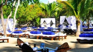A beachside lounge area with sun loungers and tables, surrounded by palm trees and covered with white canopies. - 2-Bedroom Luxury Villa in Lovely Puerto Plata with AC, WiFi sleeps 8! (Puerto Plata)
