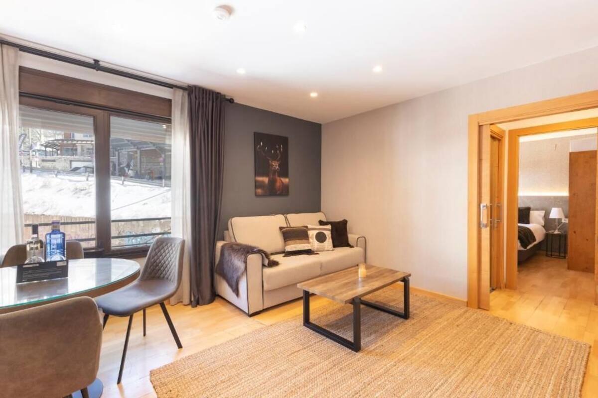 Een moderne woonkamer met een bank, salontafel en een glazen eettafel.