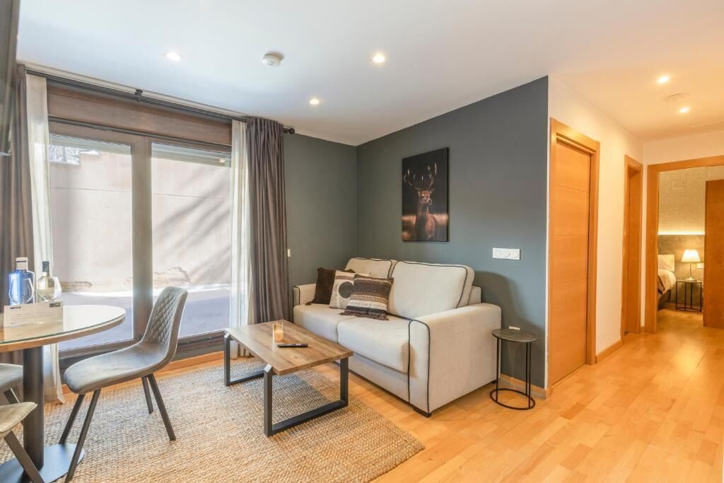 En moderne stue med sofa, sofabord og et spiseområde med bord og stole.