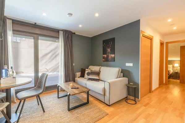 Una sala de estar moderna con un sofá, una mesa de centro y un comedor con mesa y sillas.