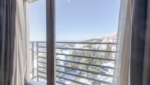 Une fenêtre donnant sur un quartier résidentiel, avec vue sur des maisons et des arbres.