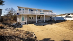 A two-story house with a covered front porch and a balcony.