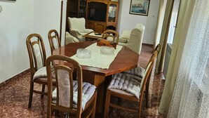 A dining area with a wooden table, six chairs, and a cabinet with glass doors. - Apartment in Nature (Kastelir-Labinci)